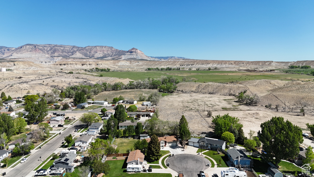 Aerial view of property's location with a mountainous background and nearby suburban area