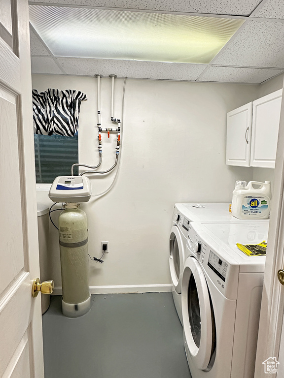 Washroom with cabinet space, separate washer and dryer, and baseboards