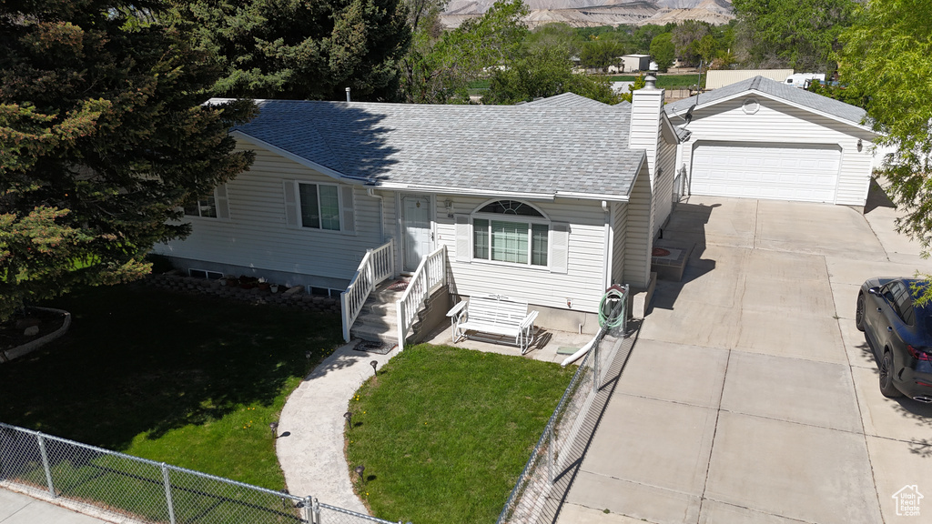 View of front of property with a garage, roof with shingles, a chimney, and driveway