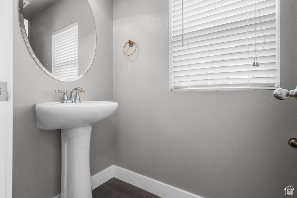 Bathroom with baseboards, tile patterned flooring, plenty of natural light, and a sink