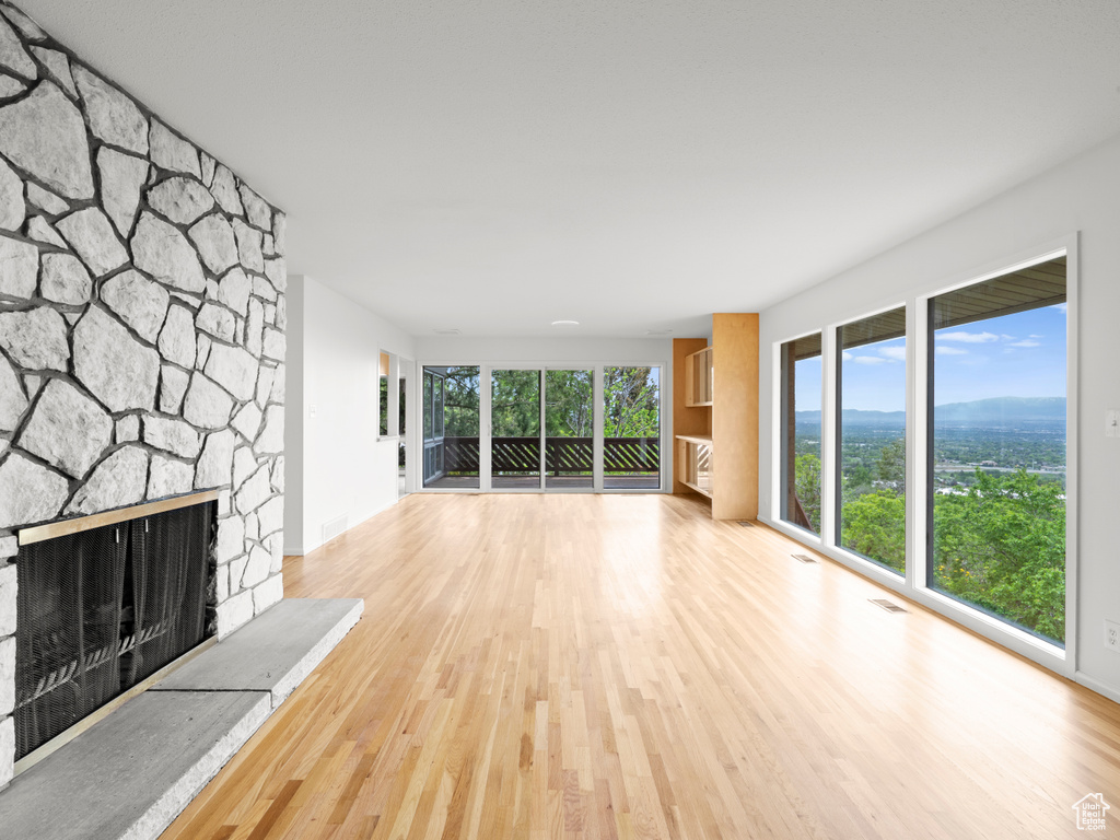 Unfurnished living room with wood finished floors and a fireplace