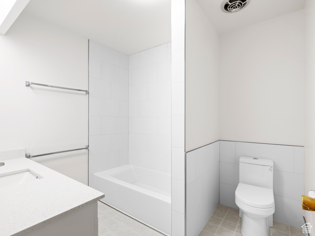 Bathroom featuring toilet, vanity, and shower / bath combination