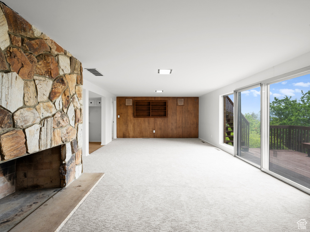 Unfurnished living room with light carpet and a fireplace