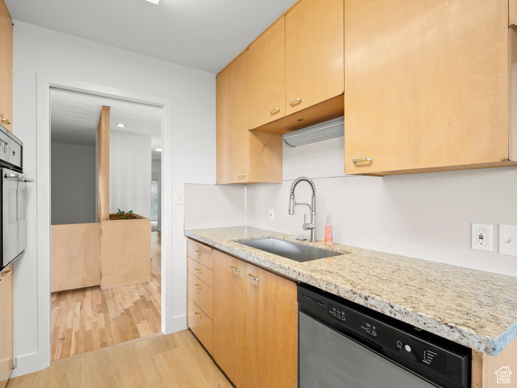 Kitchen featuring a sink, stainless steel appliances, light wood-style flooring, light stone countertops, and light brown cabinetry