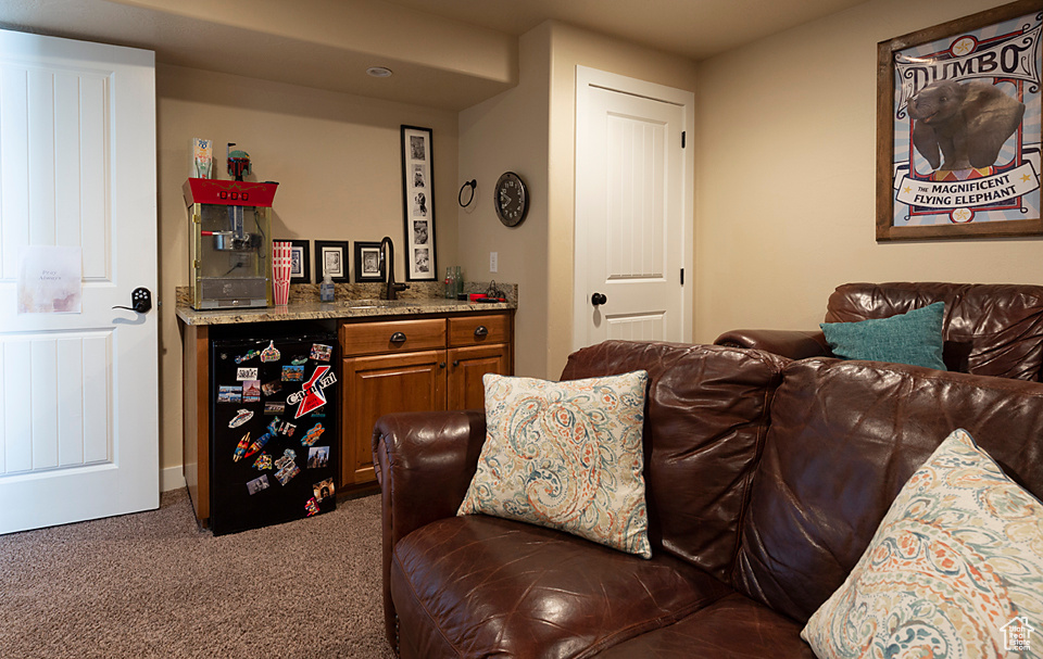 Carpeted living area featuring a bar