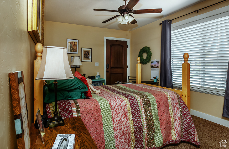 Carpeted bedroom featuring baseboards and ceiling fan