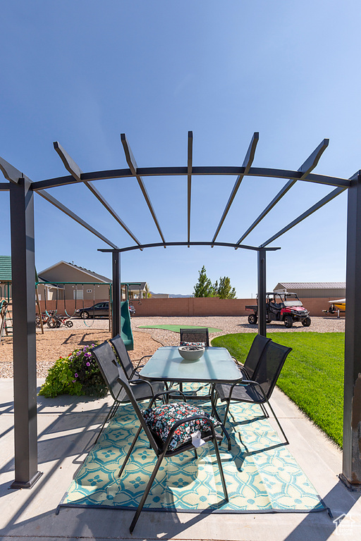 View of patio featuring a fenced backyard, outdoor dining space, and a lanai