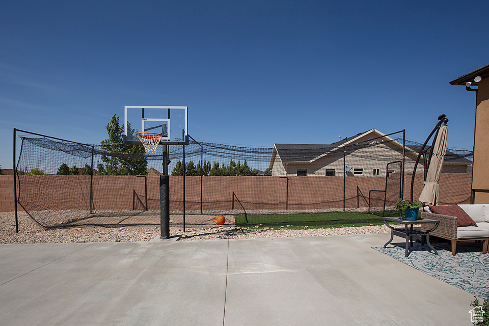 View of patio with a fenced backyard and basketball court
