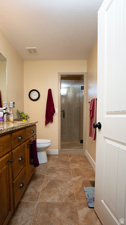 Full bathroom with a stall shower, baseboards, vanity, and toilet