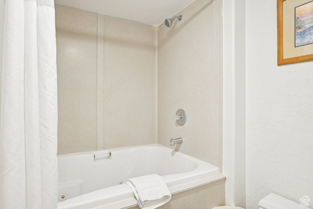 Full bathroom featuring shower / tub combo with curtain and toilet