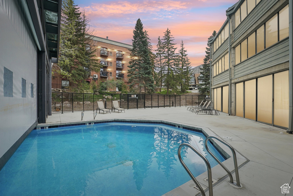 Community pool featuring a patio area and fence