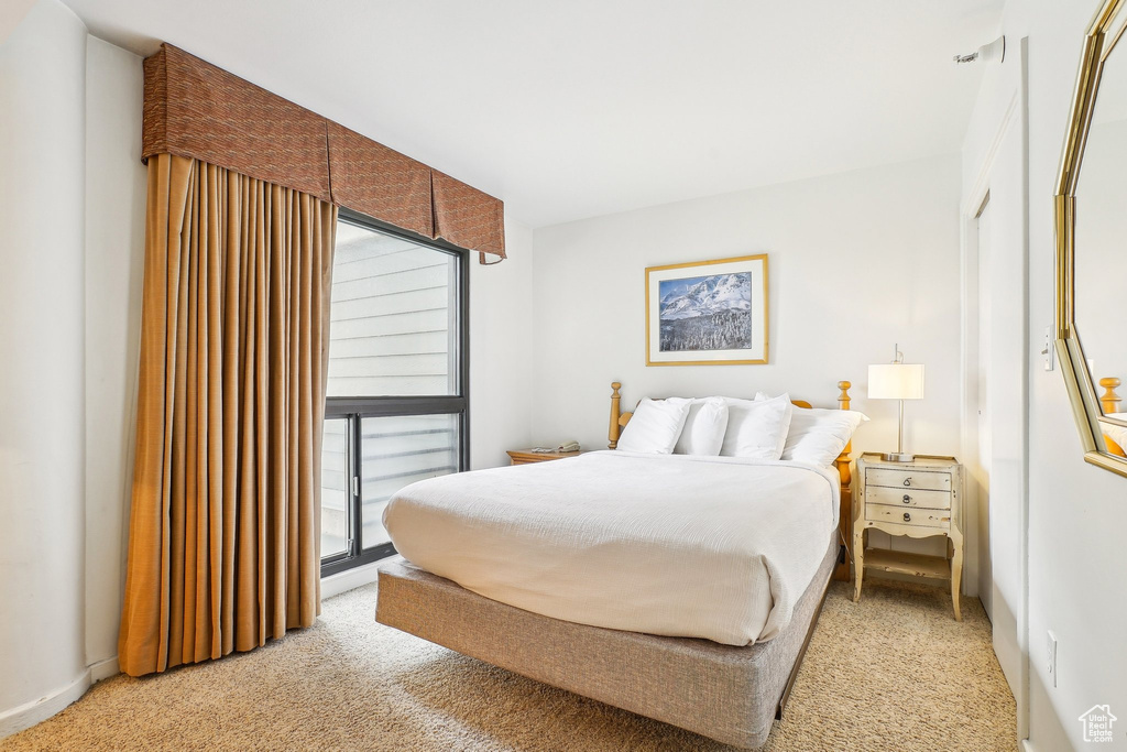 Bedroom with light colored carpet and access to outside