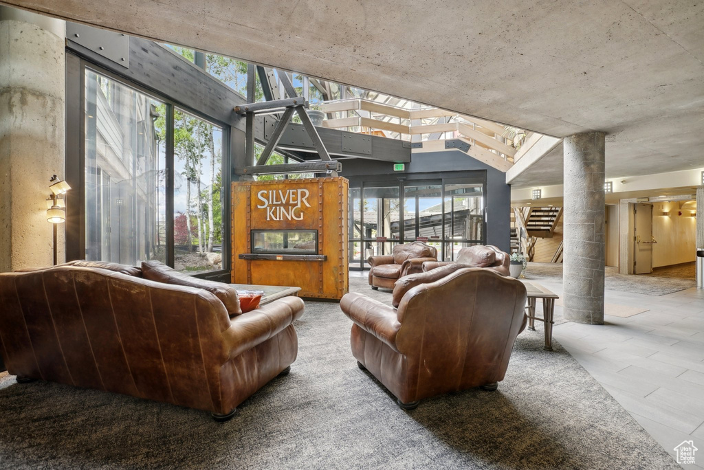 Living area with decorative columns and vaulted ceiling