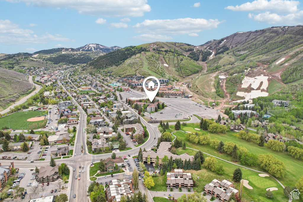 Aerial view of property and surrounding area with a mountain backdrop