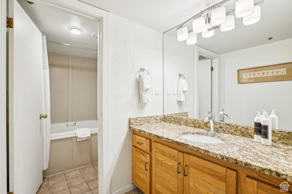 Bathroom with vanity, tile patterned floors, and bathtub / shower combination