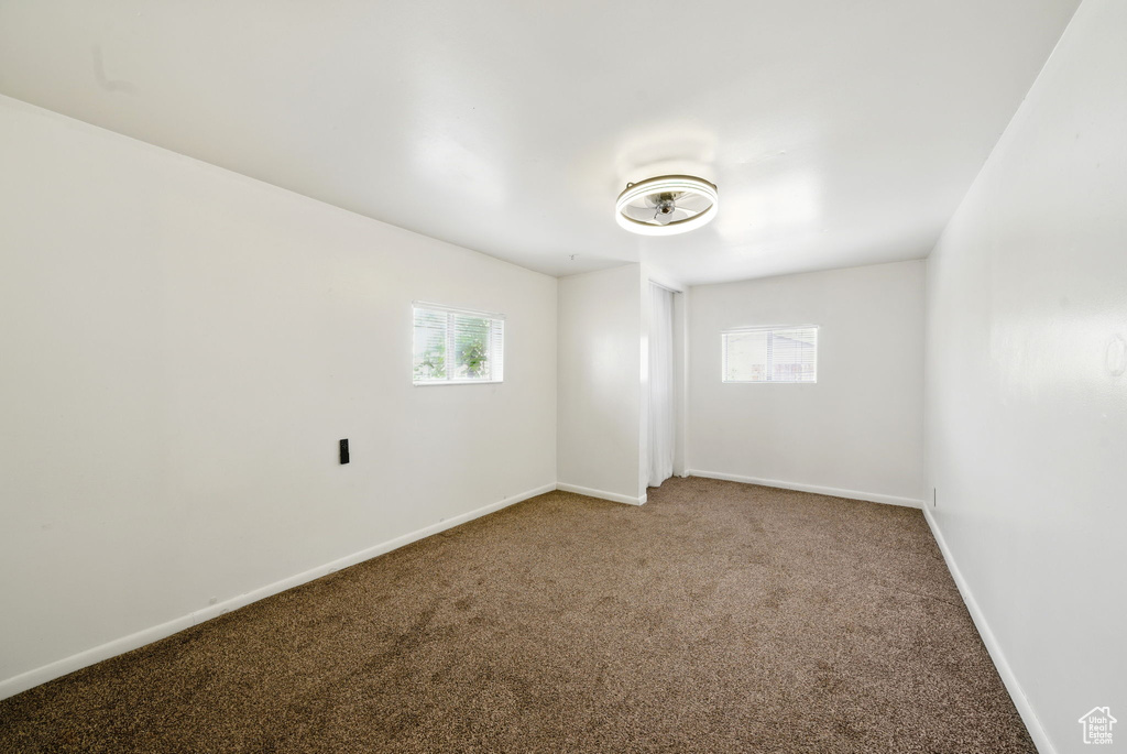 Carpeted spare room with plenty of natural light and baseboards
