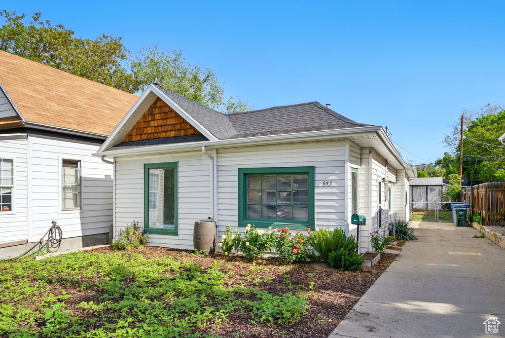 View of front facade featuring fence and concrete driveway