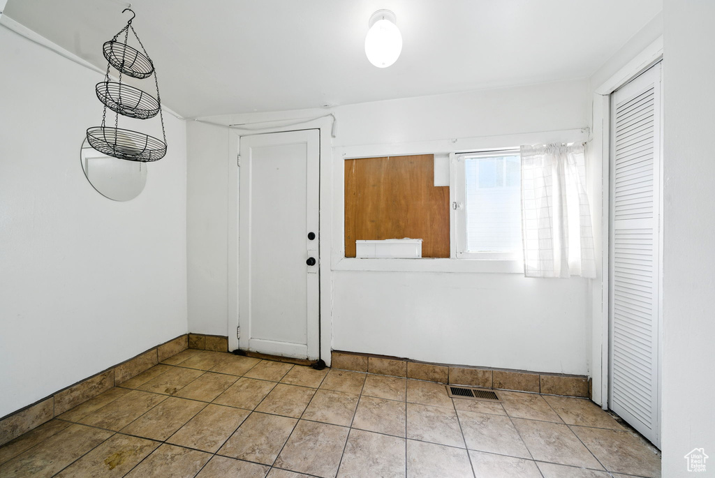 Foyer with baseboards and tile patterned floors
