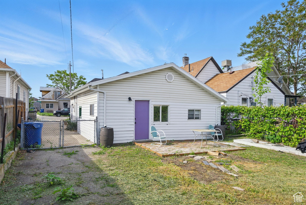 Back of property featuring a gate and a patio