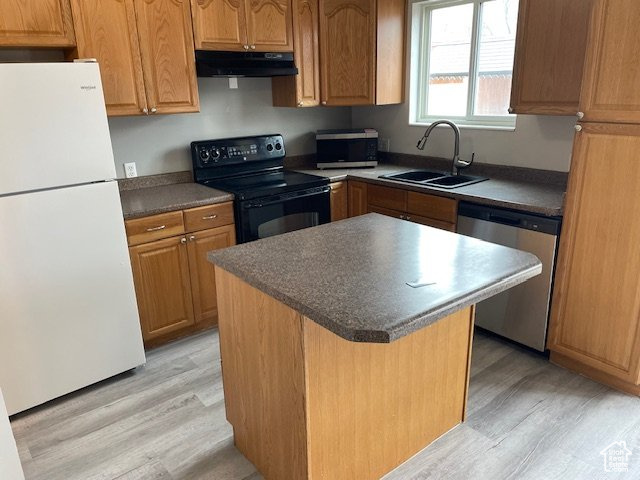 Kitchen with freestanding refrigerator, black range with electric cooktop, stainless steel dishwasher, under cabinet range hood, and a sink