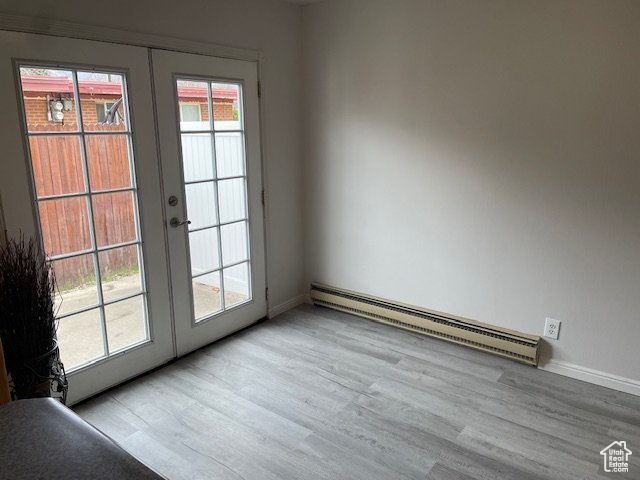 Entryway with a baseboard heating unit, french doors, wood finished floors, and baseboards