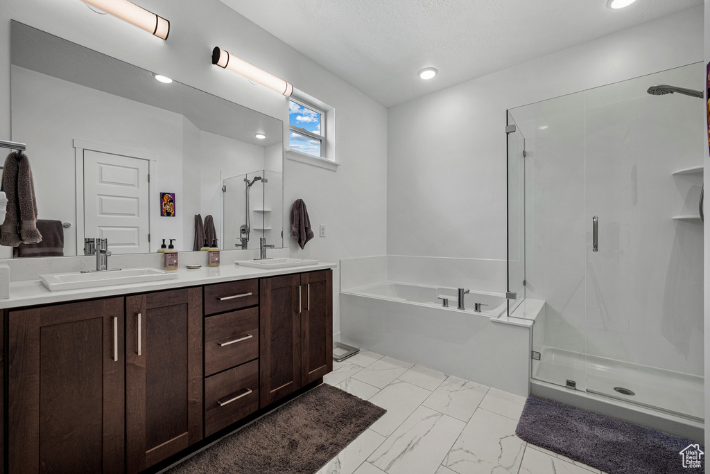 Bathroom with a stall shower, marble look tile flooring, a bath, double vanity, and recessed lighting