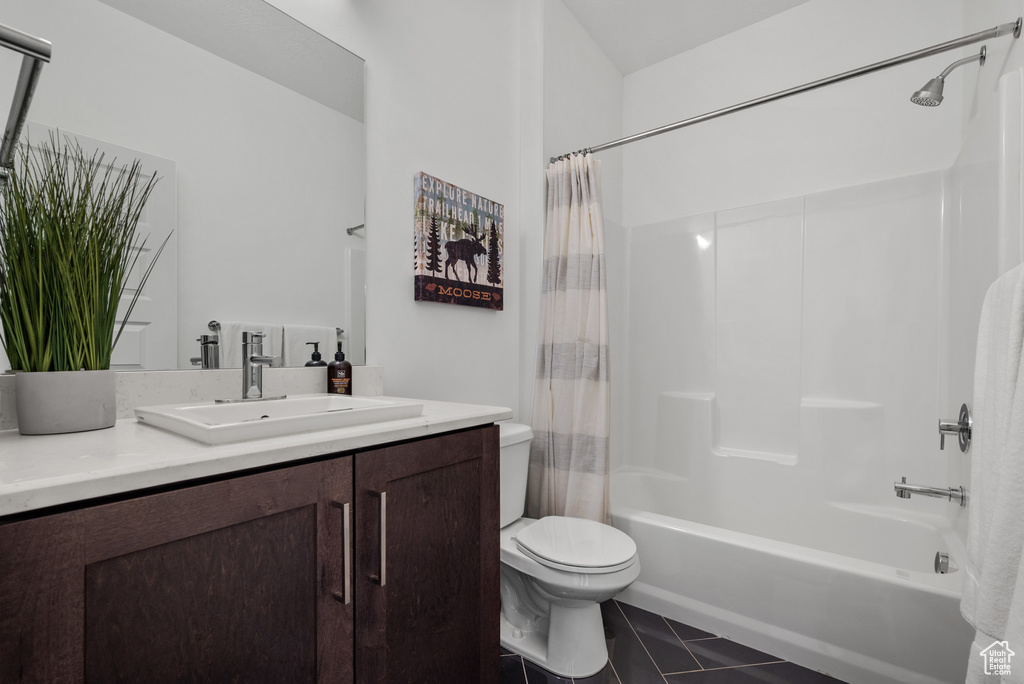 Bathroom featuring toilet, shower / bath combination with curtain, vanity, and tile patterned flooring