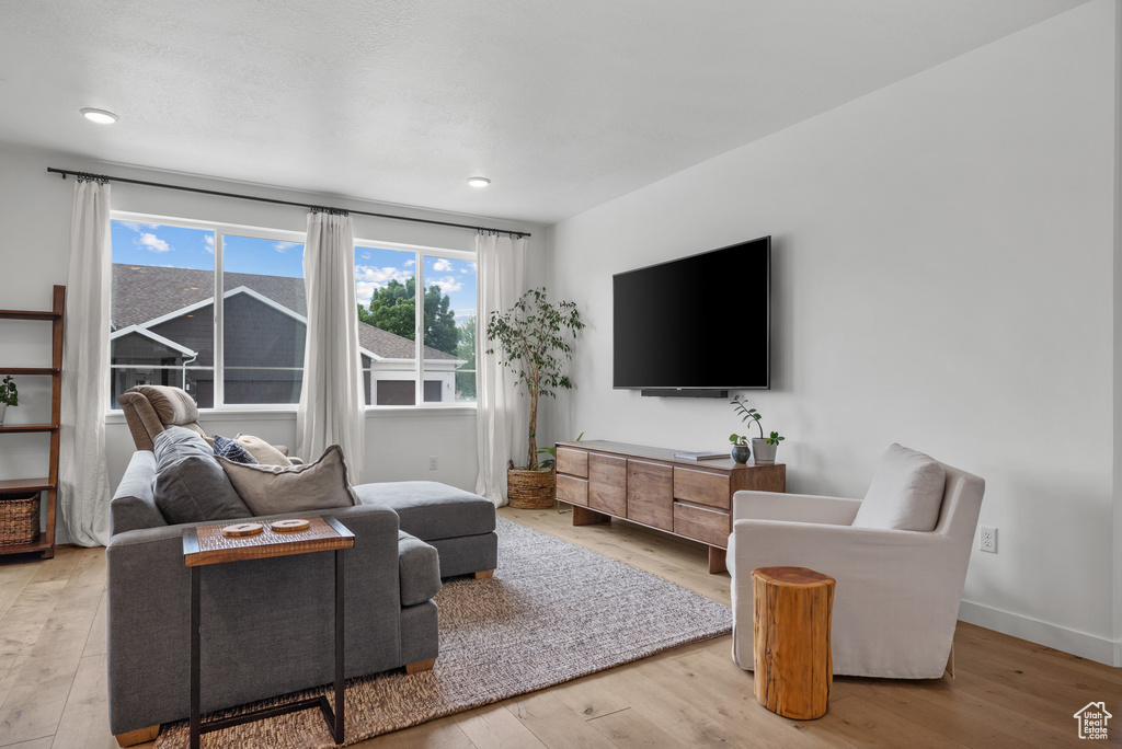 Living area featuring wood-type flooring, baseboards, and recessed lighting