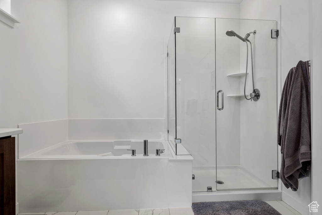 Bathroom featuring a shower stall, a bath, and tile patterned floors