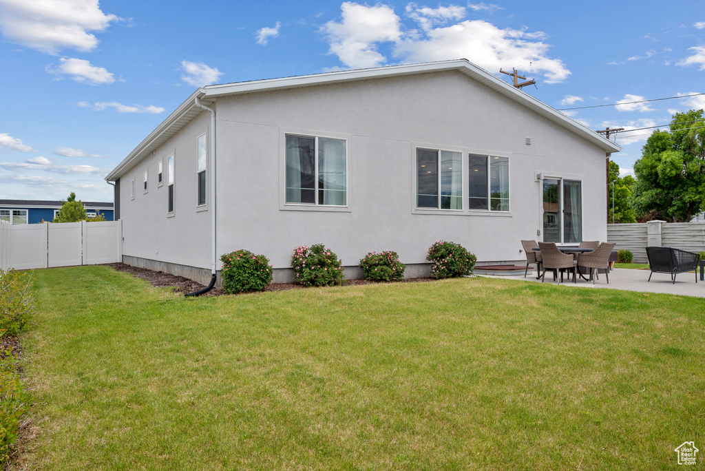 Back of house with a patio area and stucco siding