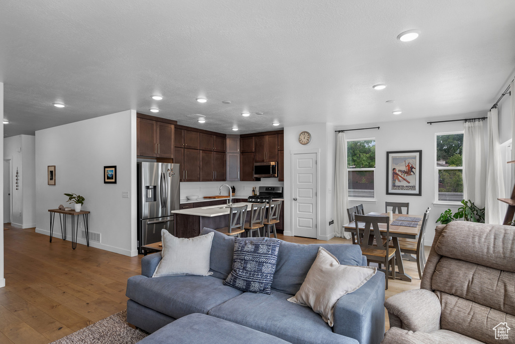 Living room featuring recessed lighting, light wood finished floors, and baseboards
