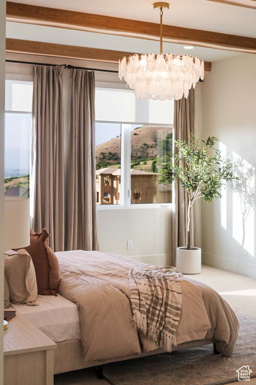 Bedroom featuring beam ceiling and a chandelier