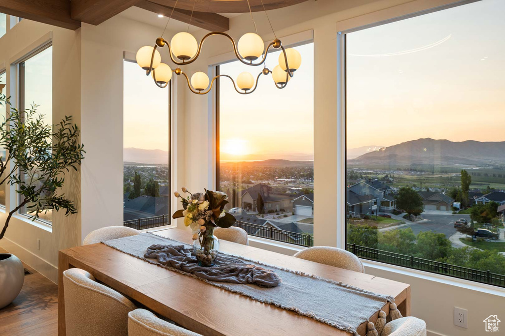 Dining area featuring wood finished floors, a mountain view, a chandelier, and baseboards