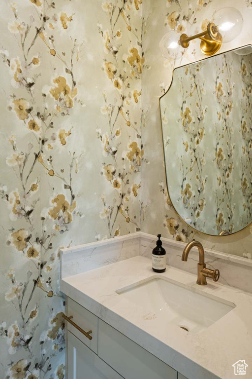 Bathroom with wallpapered walls and vanity