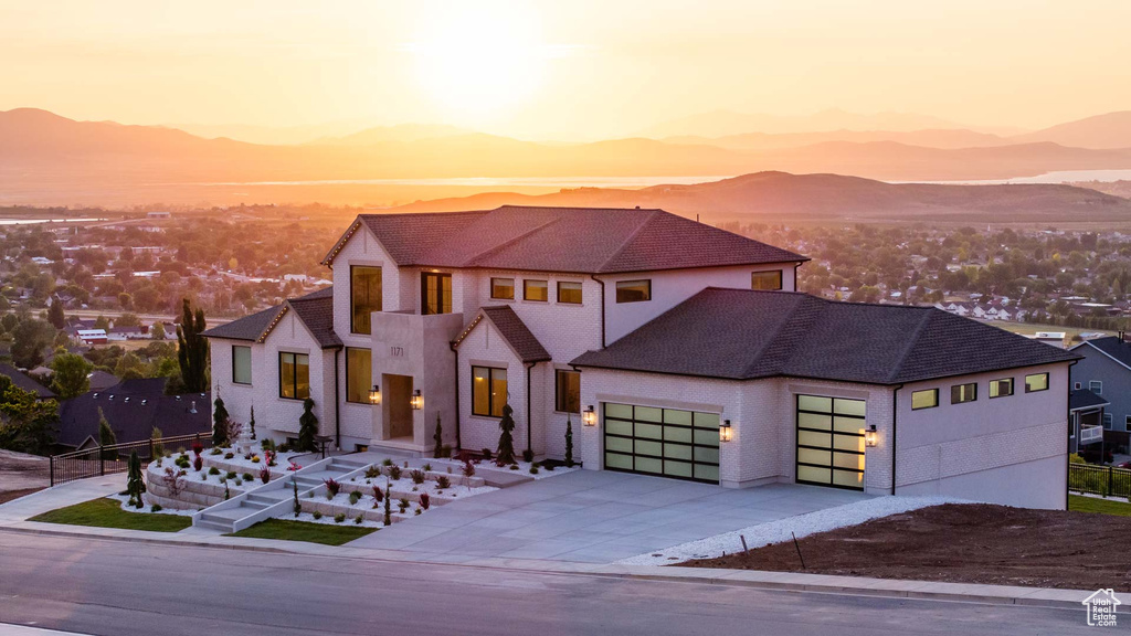 View of front facade featuring an attached garage, a mountain view, and concrete driveway