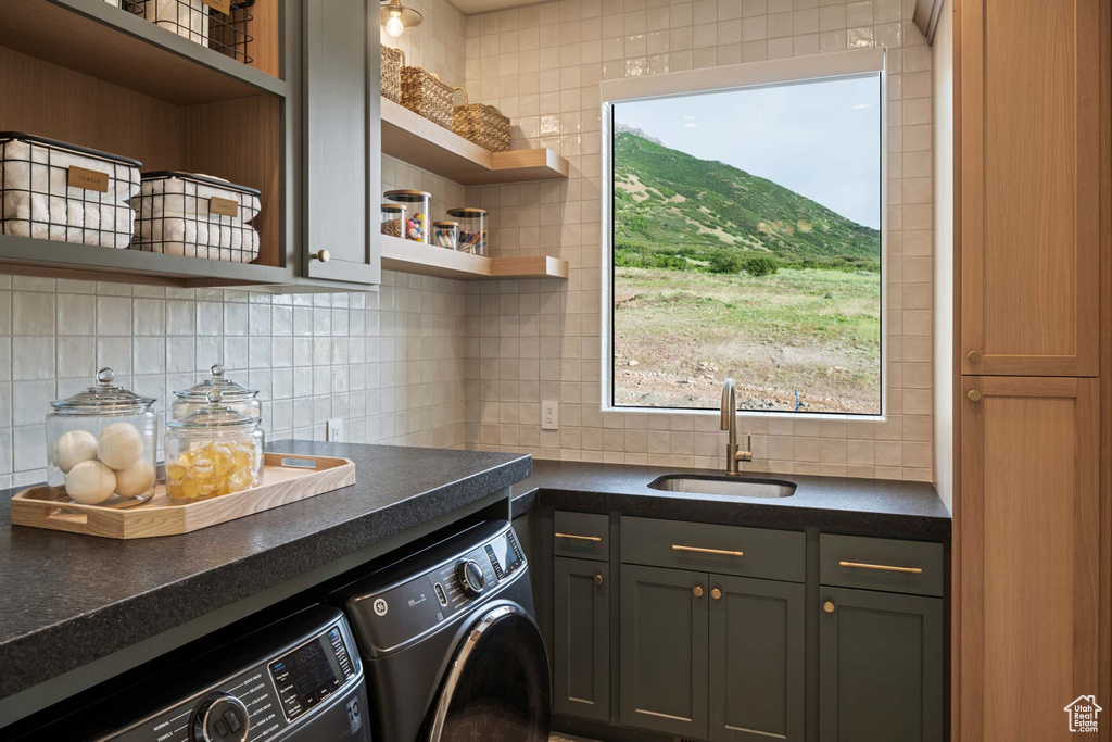 Laundry area featuring washer and clothes dryer, cabinet space, and plenty of natural light