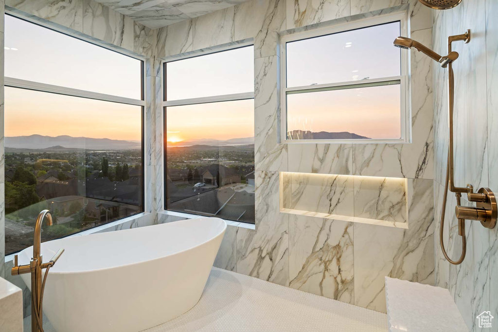 Bathroom featuring a freestanding bath, a marble finish shower, and a mountain view