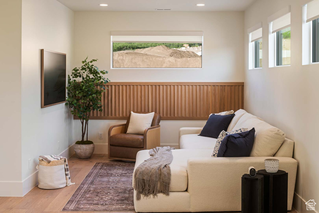 Living area with wood finished floors, baseboards, and recessed lighting