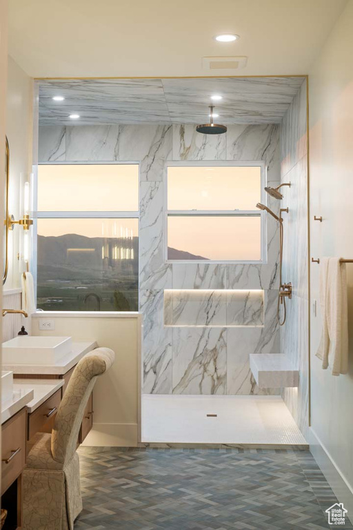 Full bath featuring vanity, healthy amount of natural light, recessed lighting, a marble finish shower, and baseboards
