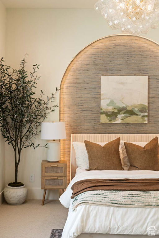 Bedroom with carpet flooring and a chandelier