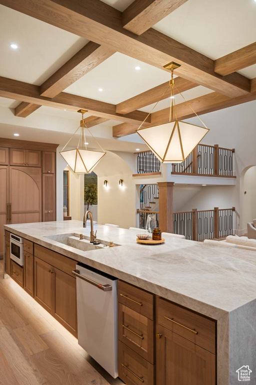 Kitchen featuring stainless steel appliances, coffered ceiling, a sink, beamed ceiling, and light wood finished floors