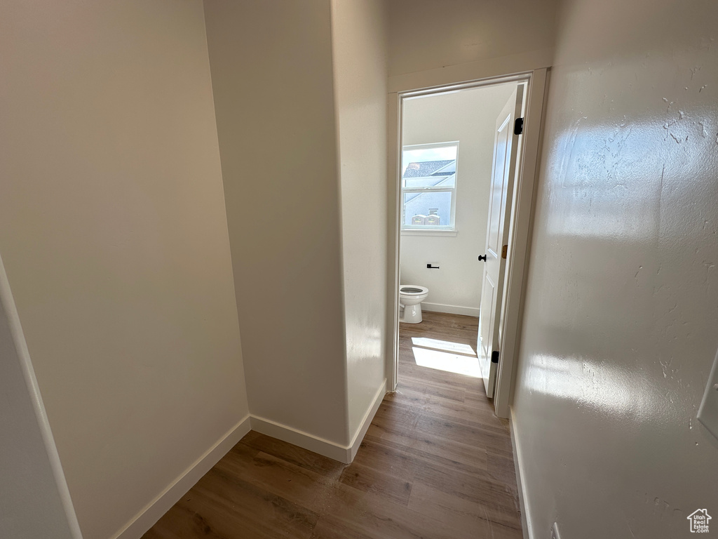 Corridor with wood finished floors and baseboards