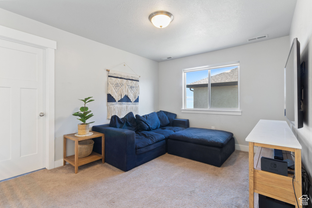 Carpeted living area featuring baseboards