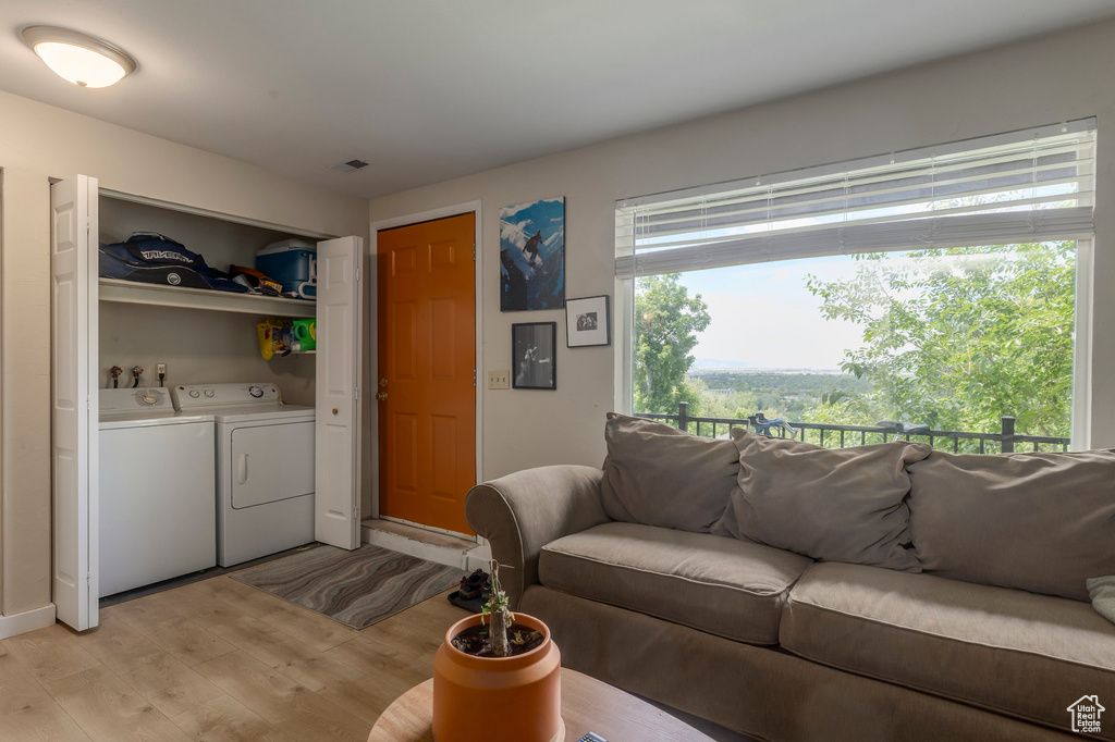 Living room featuring washer and dryer and light wood-type flooring