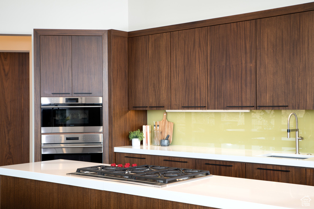 Kitchen with appliances with stainless steel finishes, a sink, and modern cabinets
