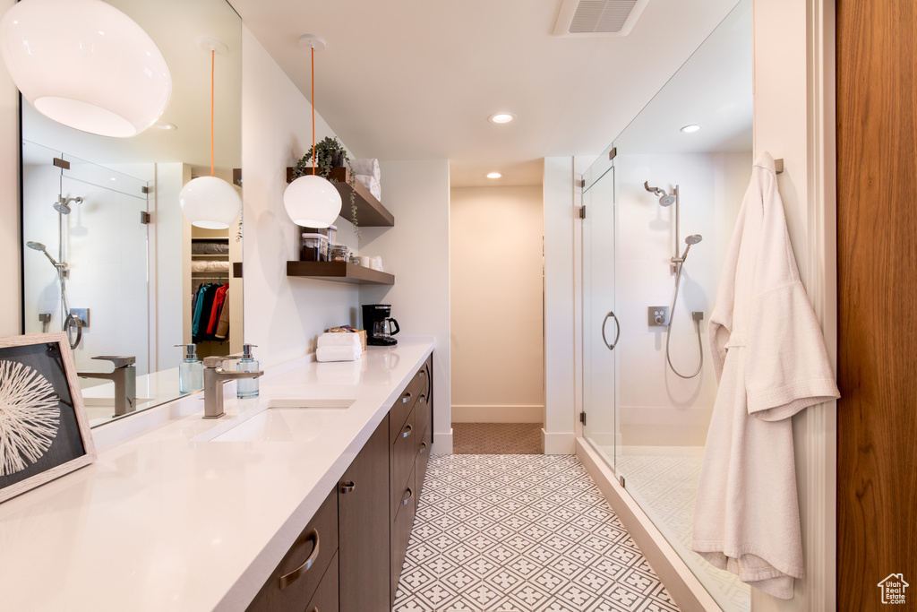 Bathroom with a stall shower, vanity, recessed lighting, baseboards, and tile patterned flooring
