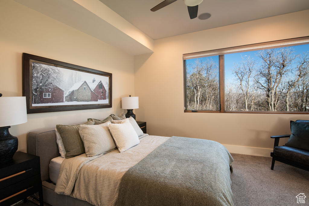 Carpeted bedroom featuring a ceiling fan and baseboards