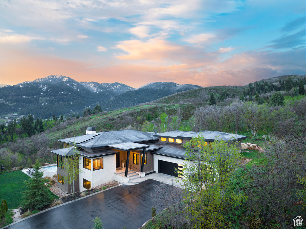 View of front of property featuring a garage, a mountain view, and driveway
