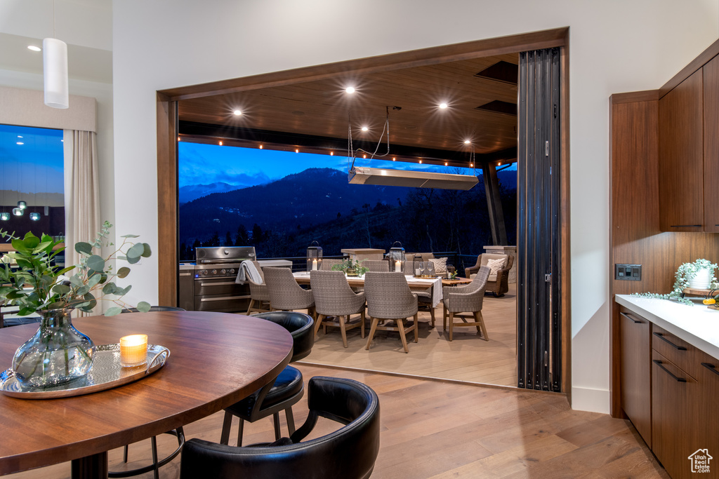 Dining room with a mountain view, light wood-type flooring, and recessed lighting