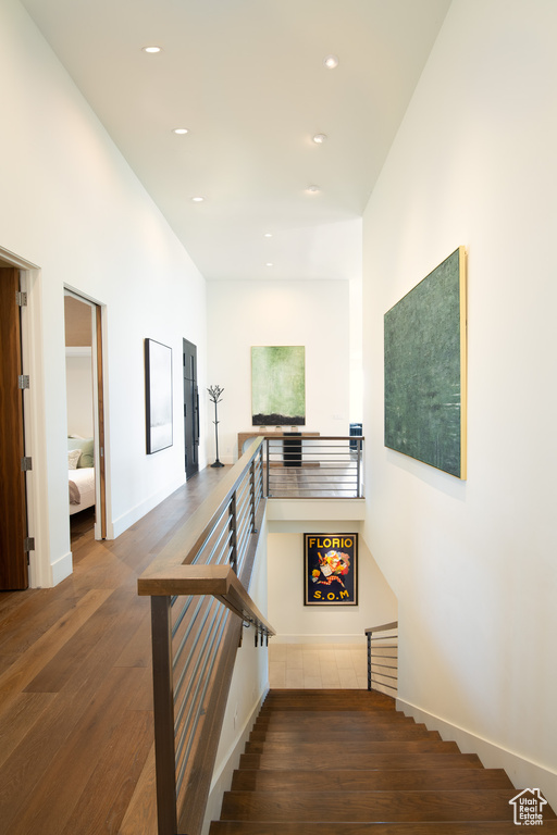 Stairs featuring wood finished floors, recessed lighting, and baseboards